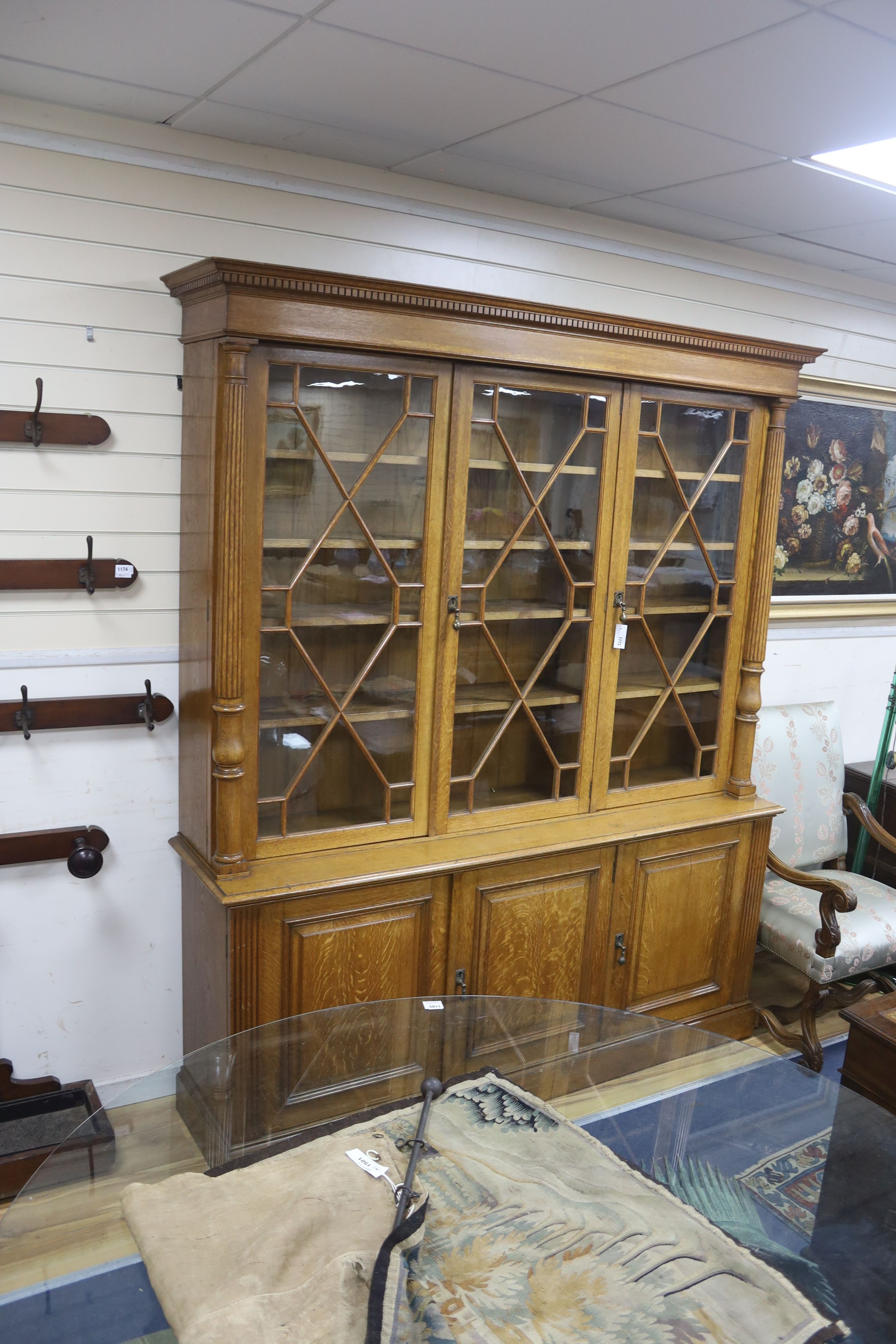 An Edwardian pale oak library bookcase by Robson and Sons of Newcastle, width 190cm, depth 45cm, height 228cm